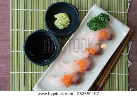 Hamachi Sushi On White Plate Along With Japanese Sauce And Green Leaf Decoration, Japanese Food, Top