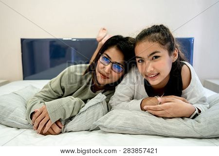 Senior Mom And Her Daughter Are Hugging, Smiling And Dringking A Warm Coffee In Some Morning.