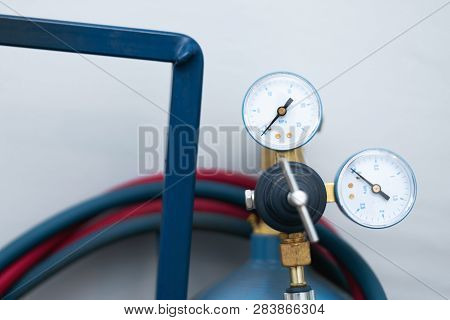 Pressure Gauge Of A Gas Baloon On A Blue Wall Background. Close Up.