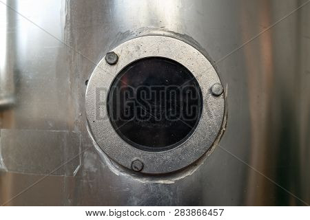 Transparent Porthole (bulleye) On A Silver Wall Tank Background.