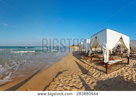 Beach Tents Canopies On Morning Paradise White Sandy Sea Beach, Apulia, Italy.