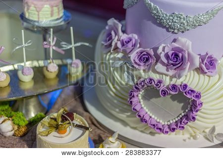 Wedding Cake And Specific Sweets Decorated With Artificial Flowers And Painted.