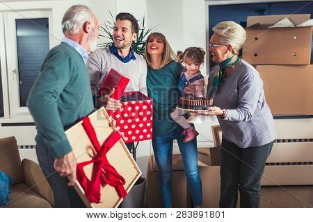 Grandmother And Grandfather Bring A Gift For Moving Into A New Apartment To Their Children