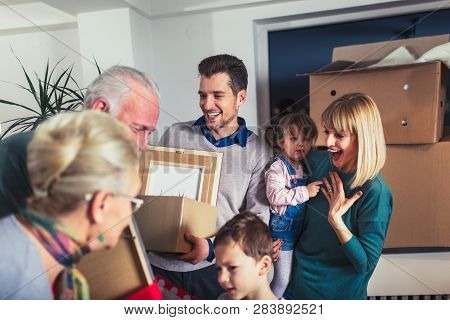 Grandmother And Grandfather Bring A Gift For Moving Into A New Apartment To Their Children