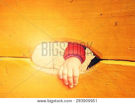 Children Hand With Small Fingers. Hand And Footholds On A Wooden Outdoor Climbing Wall.