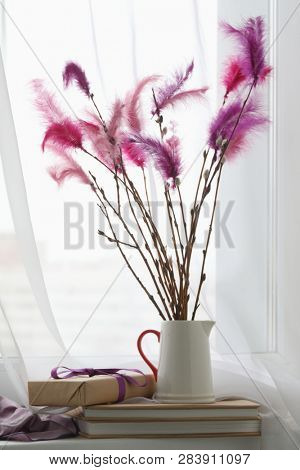 Fastelavnsris decorated with feathres and Fastelavn gifts on a window sill