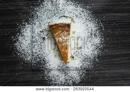 One Slice Of Cheesecake Covered With Powdered Sugar And Poured With Honey