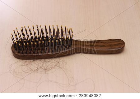 Close Up Top View Hair Fall At White Brown Plastick Comb At Wooden Table