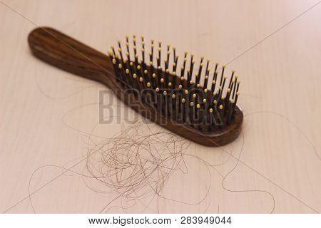 Close Up Top View Hair Fall At White Brown Plastick Comb At Wooden Table