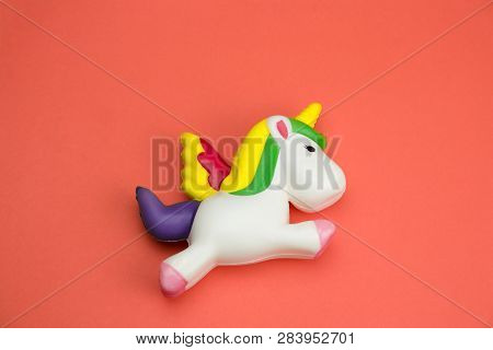 Top View Squishy Unicorn Toy On A Coral Background