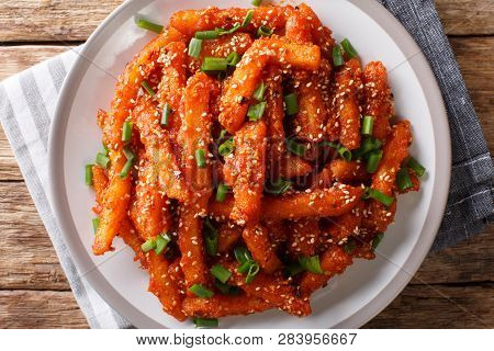 Asian Honey Chilli Potato Wedges With Hot Sweet Sauce, Sesame And Green Onions Close-up. Horizontal