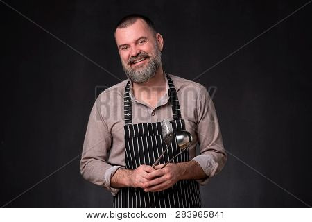 Maure Bearded Man In Apron Is Holding A Ladle Kitchen.