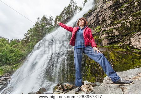 Tourist Woman At Svandalsfossen In Norway, Powerful Waterfall In Norwegian Mountains. National Touri