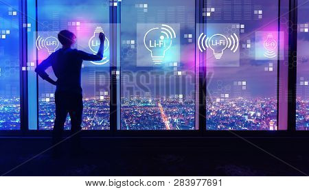 Lifi Theme With Man Writing On Large Windows High Above A Sprawling City At Night