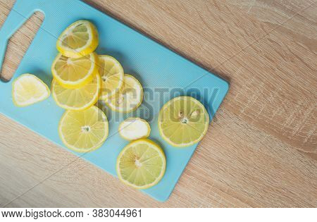 Sliced Lemon Fruits On Cutting Board Over Wooden Table. View From Above