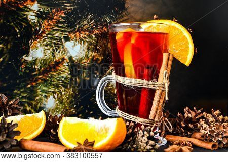 Mulled Wine Hot Christmas Drink With On A Dark Background. Orange Slices, Cinnamon Sticks, Christmas