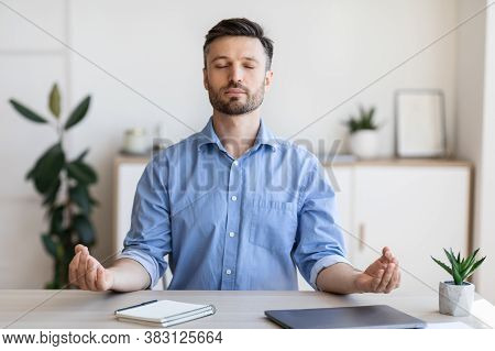 Office Zen. Relaxed Male Entrepreneur Meditating At Workplace, Coping With Stress At Work, Sitting A
