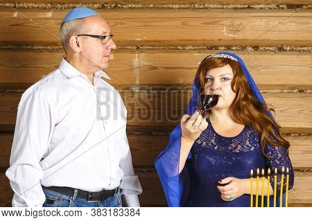 Jewish Family Husband And Wife In Rosh Ashana At The Festive Table With Burning Candles. Woman Drink