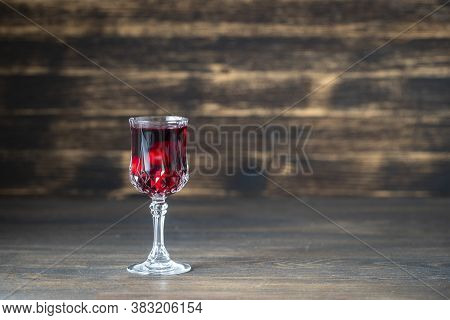 Homemade Tincture Of Red Cherry In A Wine Crystal Glass On Wooden Background, Ukraine