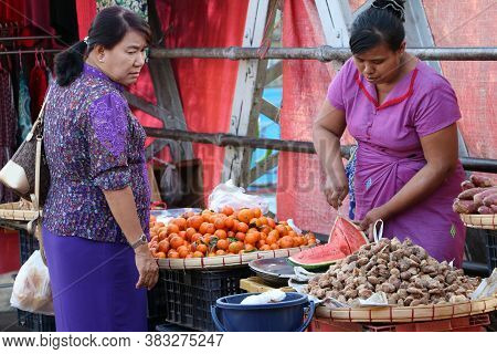 Yangon, Myanmar, Feb 20, 2019 : Myanmese Female Street Vendor Selling Fruits Is Slicing Watermelon A