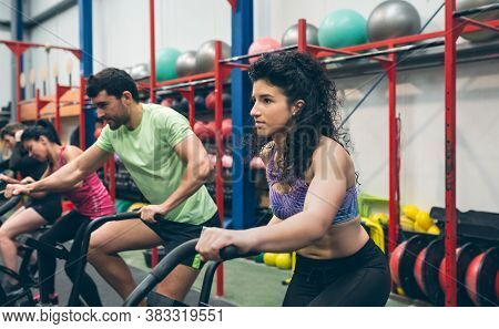 Group Of Athletes Doing Air Bike At The Gym