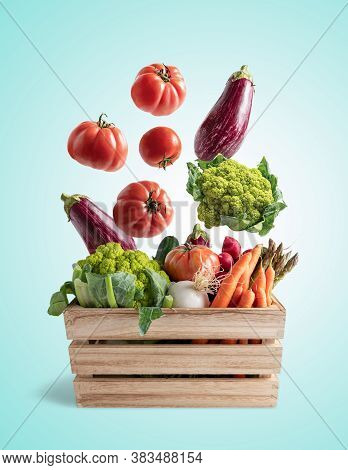 Wooden Box With Flying Vegetables, On Blue Background