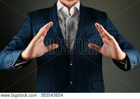 A Man In A Suit Spreads His Arms. A Man In A Suit Spreads His Arms To The Side On A Black Background
