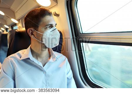 Travel Safely On Public Transport. Young Man With Kn95 Ffp2 Face Mask Looking Through Train Window. 