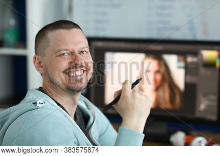 Smiling Man Holding An Electronic Pen In His Hand From Behind On Computer Background. Learning Profe
