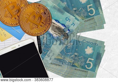 5 Canadian Dollars Bills And Golden Bitcoins With Smartphone And Credit Cards. Cryptocurrency Invest