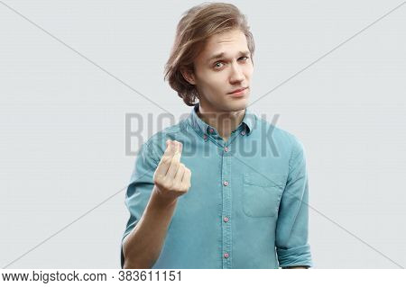 Portrait Of Serious Handsome Long Haired Blonde Young Man In Blue Casual Shirt Standing With Money H