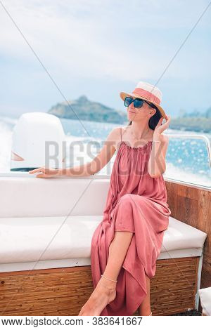 Woman In Hat And Dress Sailing On Boat In Clear Open Sea