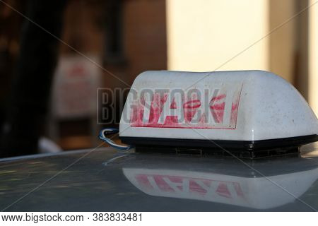 Taxi Light Sign Or Cab Sign In Drab White And Fade Away Red Color With White Text On The Car Roof At