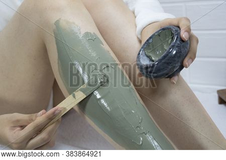 Spa, Moisturizing, Treatment. A Woman Applies A Clay Mask With A Spatula To The Skin Of Her Legs. Ir