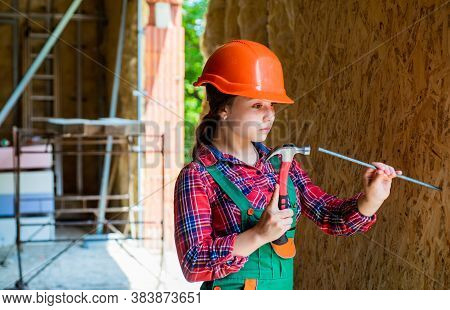 Girl Hammering A Nail. Carpentry And Woodworking Concept. Teen Child Using Hammer Tool. Building And