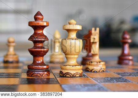 Chess Board Game With Focus On Wooden 'black' Queen Pieces On Blurry Background
