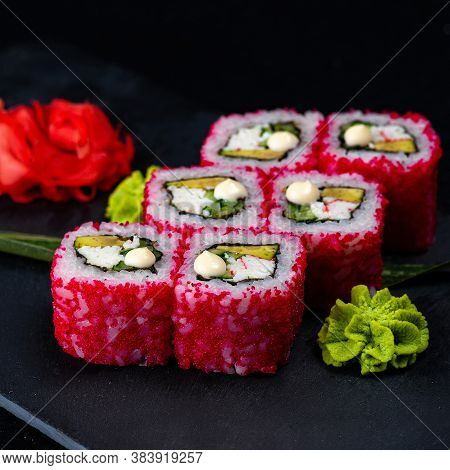 Japanese Sushi In Red Flying Fish Roe Isolated On Dark Background. California Roll With Salmon, Cucu