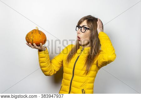 Sed Face And Holding A Pumpkin Hand Holding His Head On A Light Background. Halloween Concept, Autum