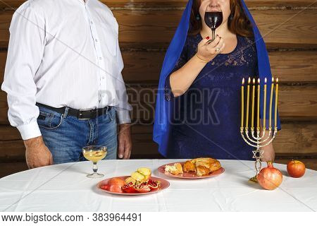 Jewish Family Husband And Wife In Rosh Ashana At The Festive Table With Burning Candles. Woman Drink