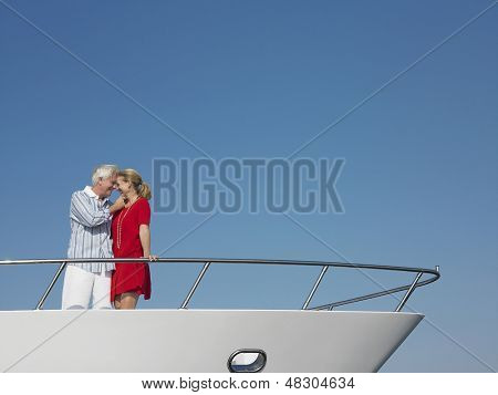 푸른 하늘에 대 한 요트의 뱃머리에 서 있는 로맨틱 중간 나이 든된 부부