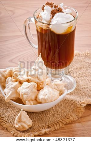 เมอแรงครีมขาวบนจานและกาแฟ