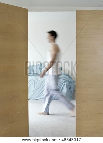 Zijaanzicht van een wazig man walking in slaapkamer