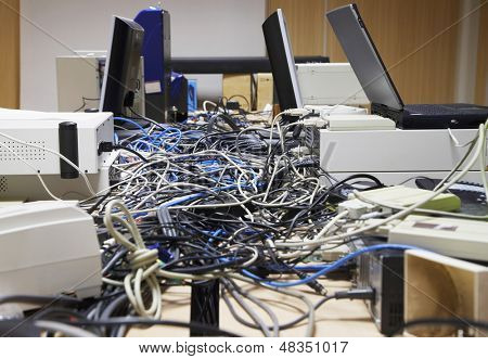 มุมมองด้านข้างของ Closeup ของ messed สายเชื่อมต่อคอมพิวเตอร์และเครื่องพิมพ์ในสำนักงาน