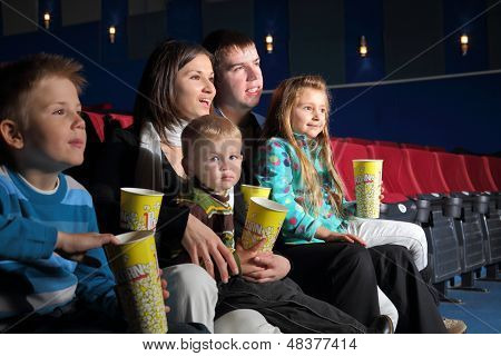 Venlige familie ser en film og spise popcorn i biografen