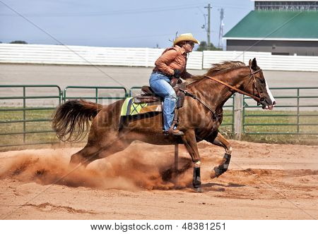 Western horse and rider competing in pole bending and barrel racing competition.