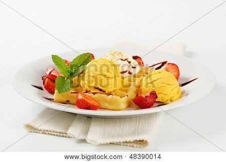 cialda belga con palline di gelato alla vaniglia e fragole fresche