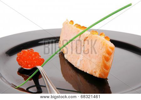 healthy fish cuisine : roasted pink salmon fillet with  onion pen , and red caviar in spoon on black dish isolated over white background