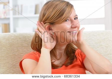 Young, smiling woman wearing deaf aid