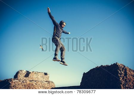 man performs freerunning jump on stones