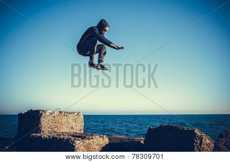 man performs freerunning jump on stones